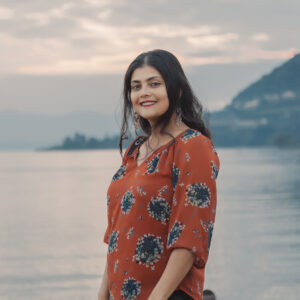 Rucha Chitnis, Director of Communications with the ocean and coastline in the background